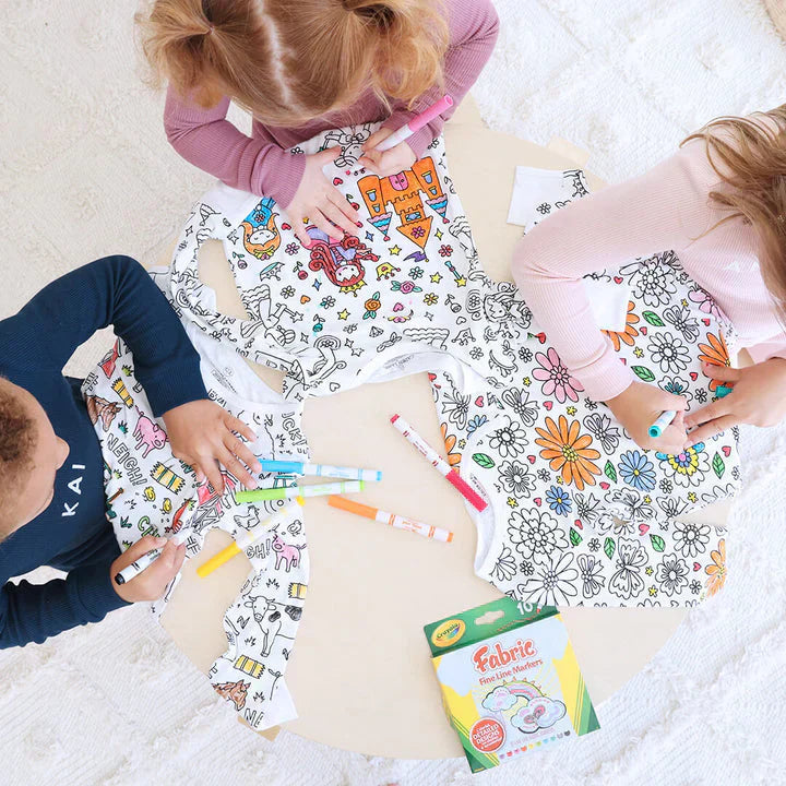 Kinder malen T-Shirts mit Stoffmalstiften an einem Tisch, kreative Aktivität, bunte Designs.