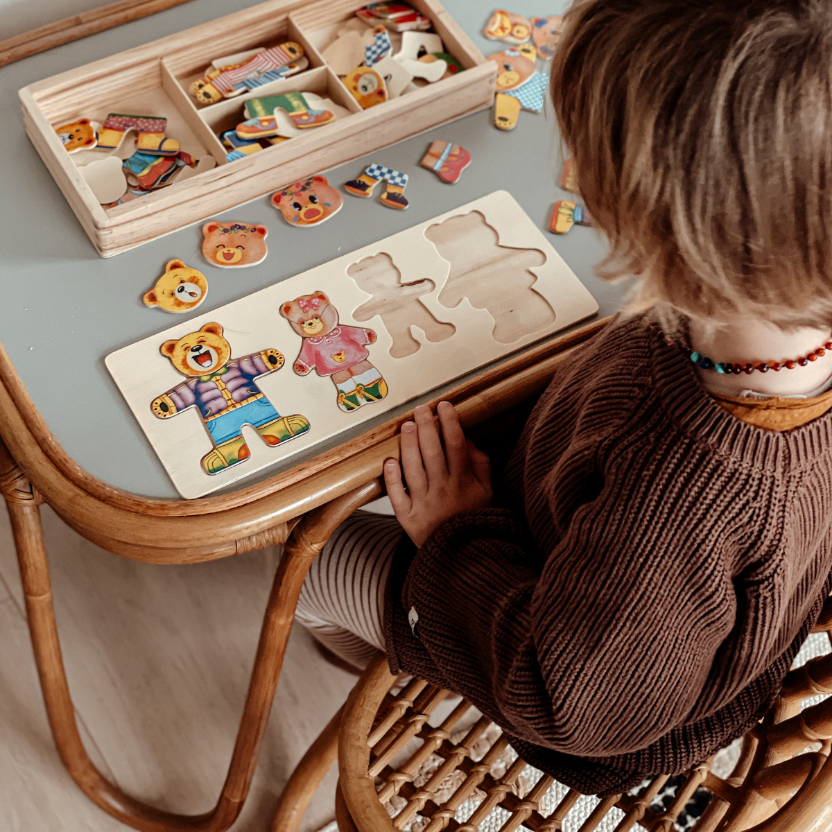 Kinderspielzeug Holzpuzzle Bär, Kind spielt am Tisch, pädagogisches Lernspielzeug, bunt