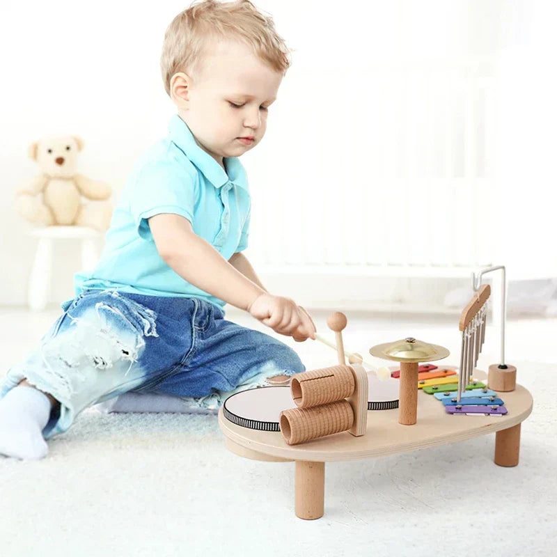 Kleinkind spielt mit Holz-Musikinstrument-Set, Xylophon, Trommel, helle Farben, pädagogisches Spielzeug.
