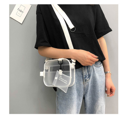 Frau mit transparenter Umhängetasche aus Kunststoff, weißer Riemen, lässiges Outfit.