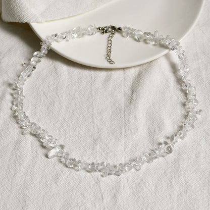 Klarer Quarzstein-Halskette auf weißem Stoff, elegantes Schmuckdesign, Damenaccessoire.