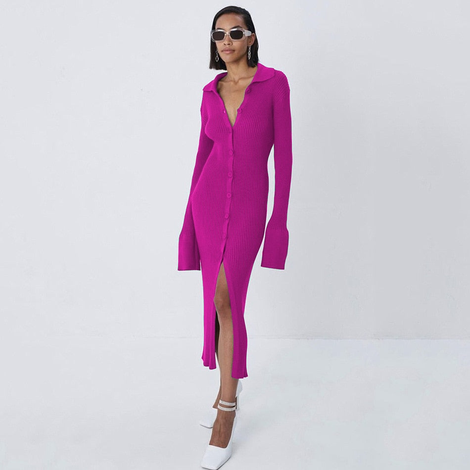 Frau in pinkem Strickkleid mit Knopfleiste und Schlitz, trägt weiße Schuhe und Sonnenbrille.