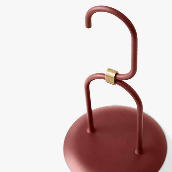 Roter Metall-Kleiderständer mit Haken und Messingdetail, modernes Design.