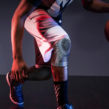 Basketballspieler mit schwarzer Kniebandage, Sportbekleidung, dynamische Bewegung.