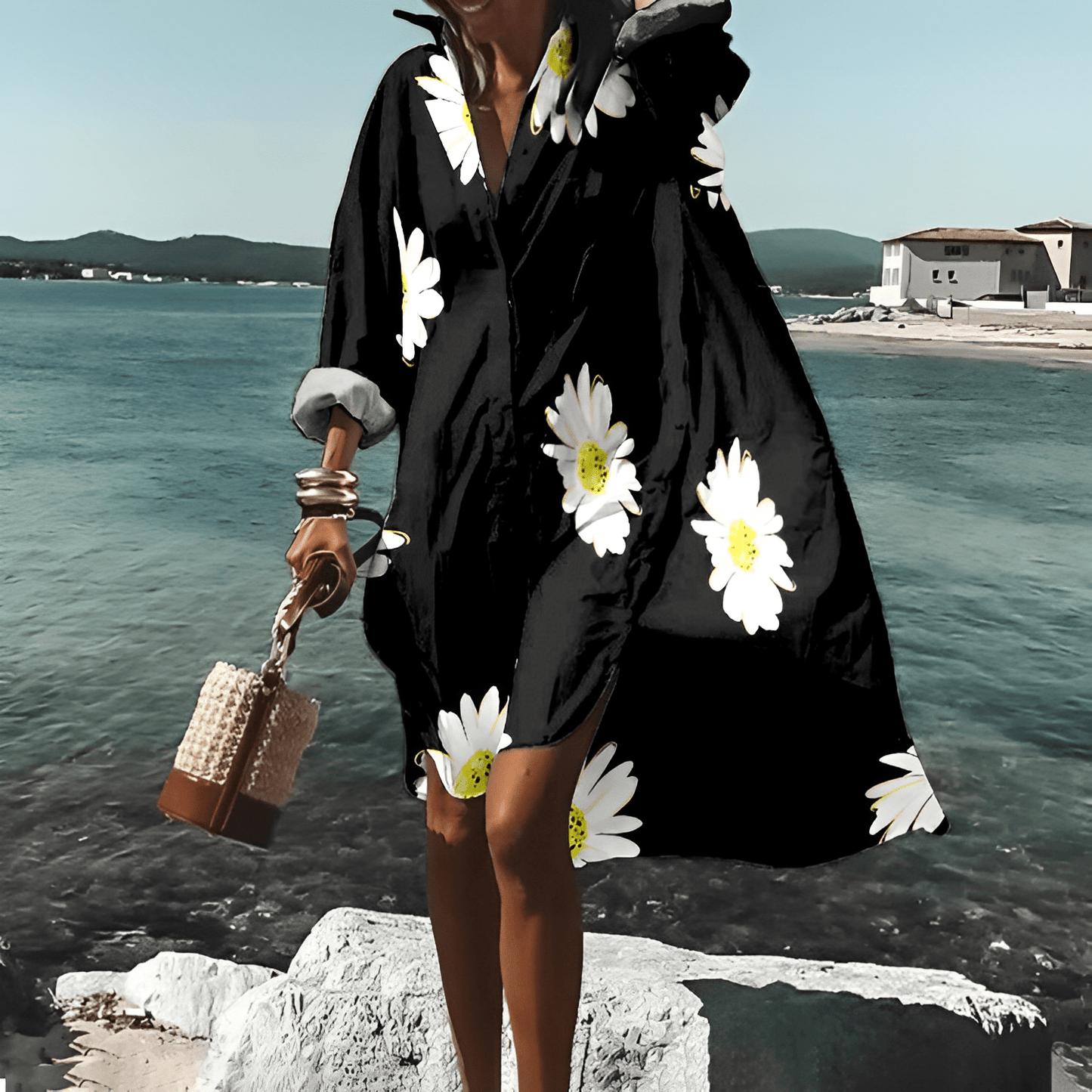 Frau in schwarzem, geblümtem, knielangem Kleid am Meer, Sommermode, Elle Vire.