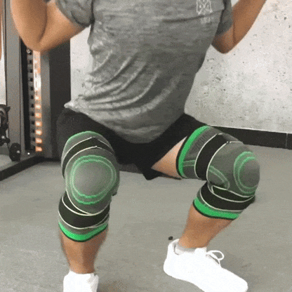 Mann beim Kniebeugen mit grünen Kniebandagen im Fitnessstudio.