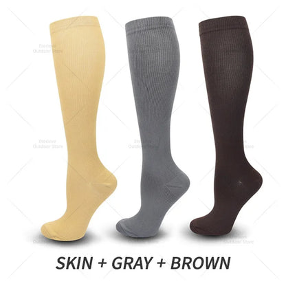 Drei Paar Kompressionsstrümpfe in Hautfarbe, Grau und Braun, knielang, unisex.