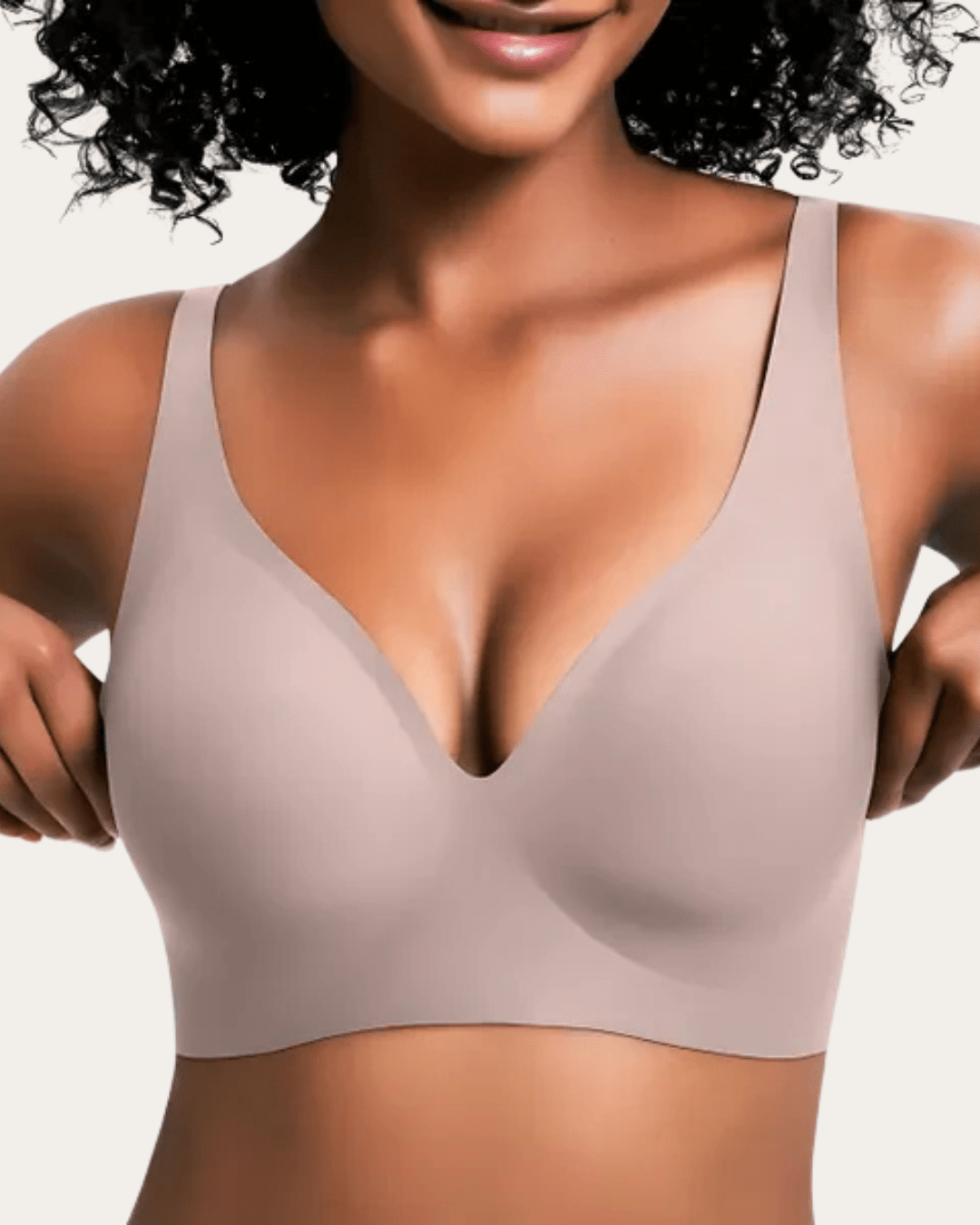 Modell bär slät bralette i ljus gråbeige nyans med V-ringning, sedd framifrån. 10