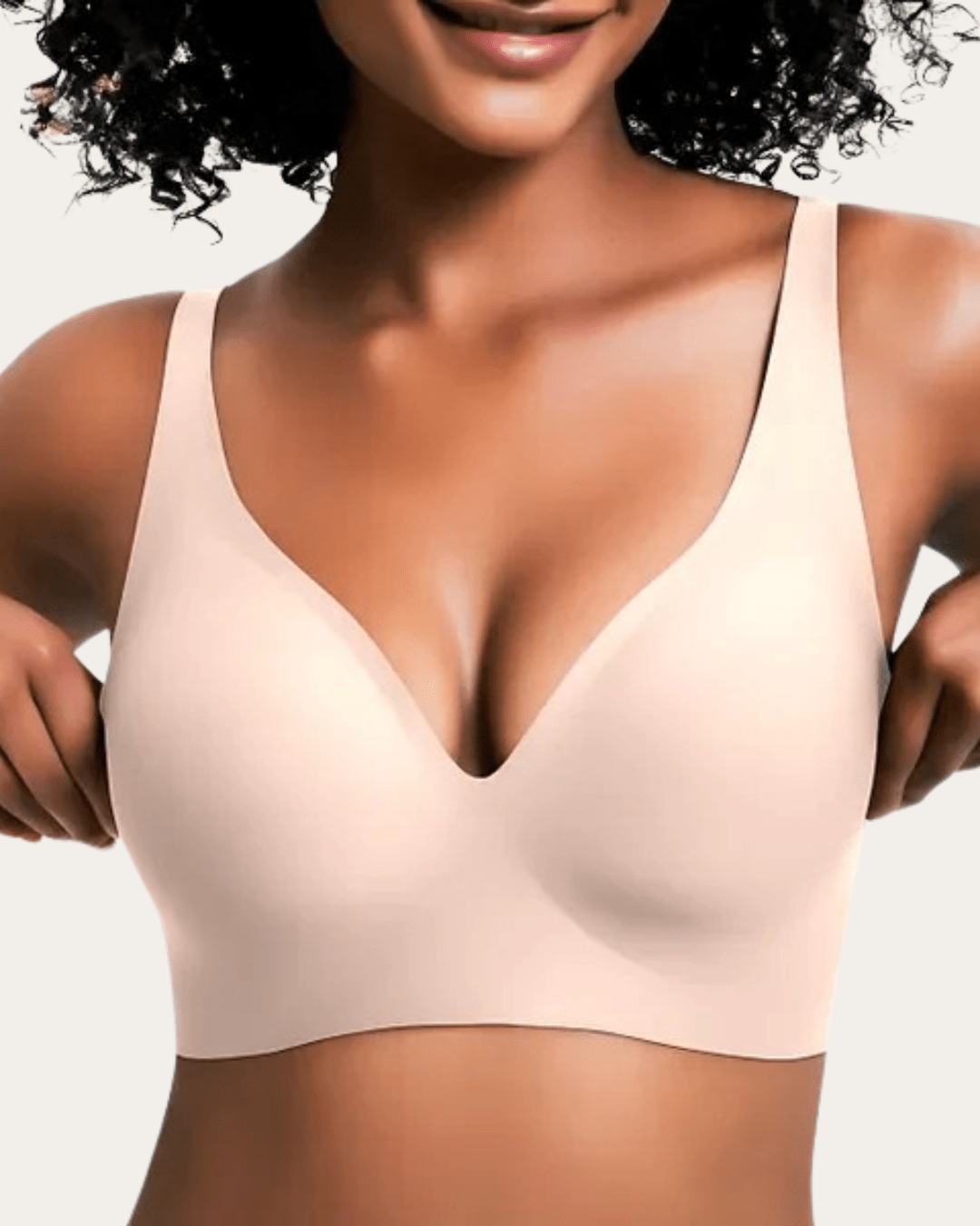 Modell bär slät bralette i ljus beige nyans med V-ringning, sedd framifrån. 6