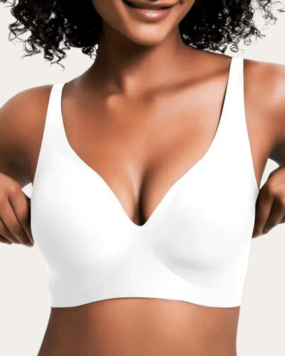 Modell bär slät vit bralette med V-ringning, sedd framifrån med händerna vid sidorna. 7