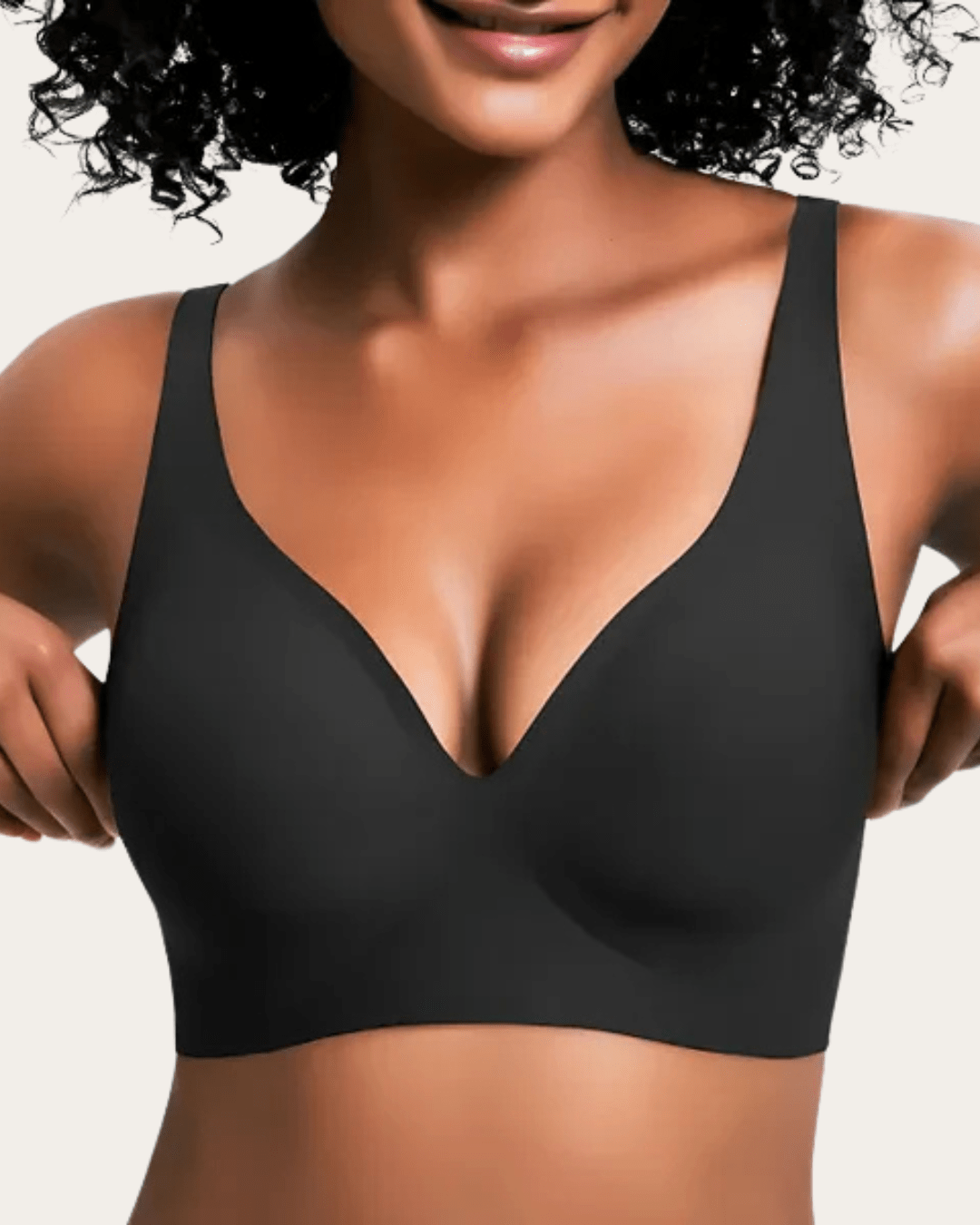 Modell bär slät svart bralette med V-ringning, sedd framifrån med händerna vid sidorna. 9