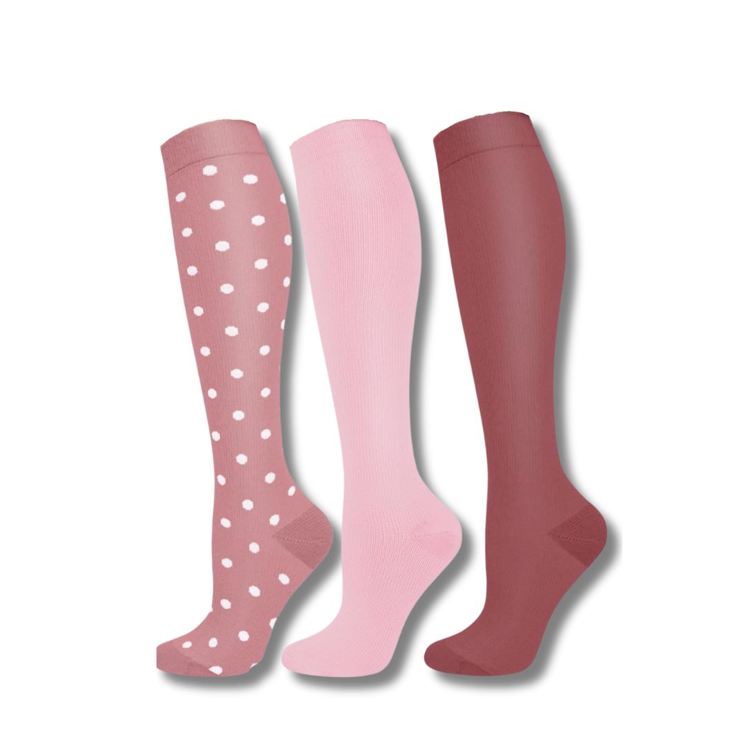 Drei Paar bunte Kompressionsstrümpfe, rosa und rot, gepunktet, für Damen.