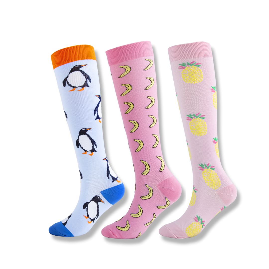 Bunte Kniestrümpfe mit Pinguin-, Bananen- und Ananas-Motiven, ideal für modische Outfits.