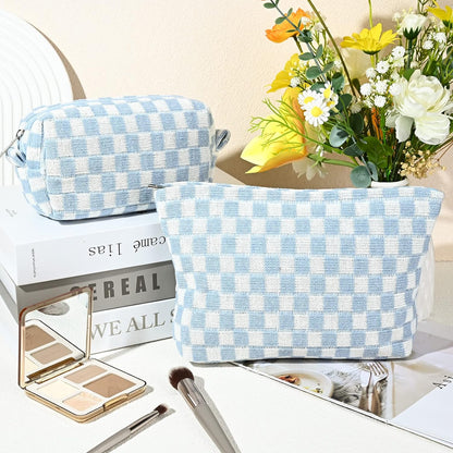 Hellblau-weiß karierte Kosmetiktasche aus Stoff, neben Blumenstrauß und Make-up-Pinsel.