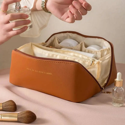 Braune Kosmetiktasche aus Leder mit Reißverschluss, gefüllt mit Pflegeprodukten und Parfümflasche.