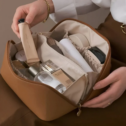 Braune Kosmetiktasche aus Leder, gefüllt mit Make-up-Produkten, ideal für Reisen und Organisation.
