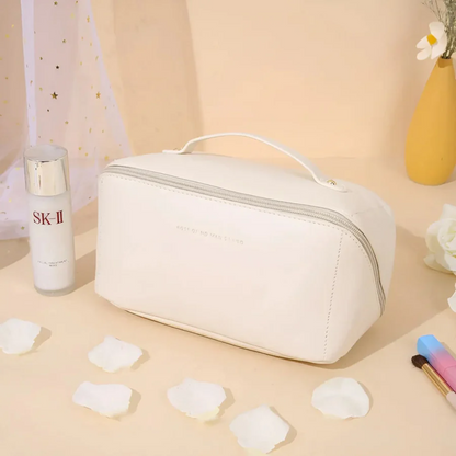 Weiße Kosmetiktasche aus Leder mit Reißverschluss, ideal für Reisen, neben SK-II Flasche.