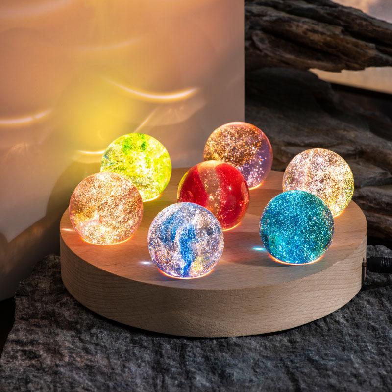 Sechs bunte Kristallkugeln auf Holzsockel, LED-Licht, dekorative Beleuchtung, modern.