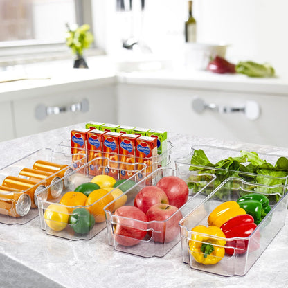 Küchenaufbewahrung aus klarem Kunststoff mit Obst, Gemüse, Getränkedosen und Saftpackungen.