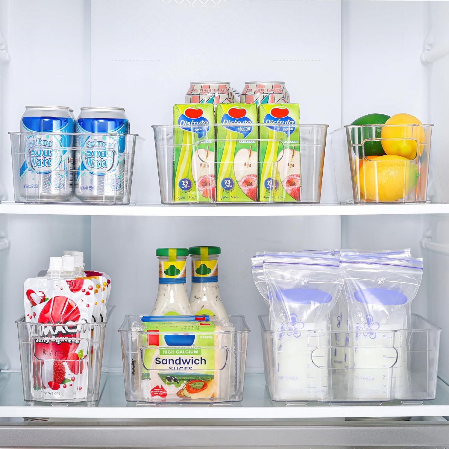 Kühlschrank-Organizer mit Getränkedosen, Saftpackungen, Zitronen, Saucenflaschen und Milchbeuteln.