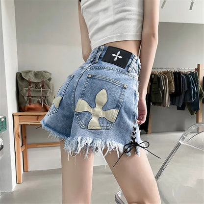 Frau in blauen Jeansshorts mit Fransen und Kreuzmuster, modisch, lässig, Sommerkleidung.