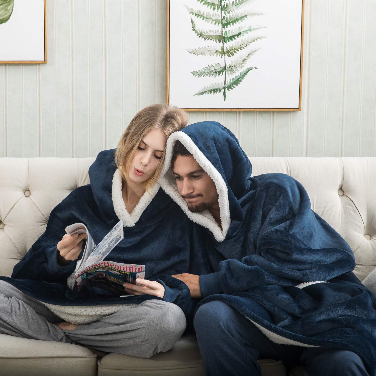 Paar in blauen Kuscheldecken auf Sofa, gemütlich, lesen Zeitschrift, Wohnzimmer, Winter.