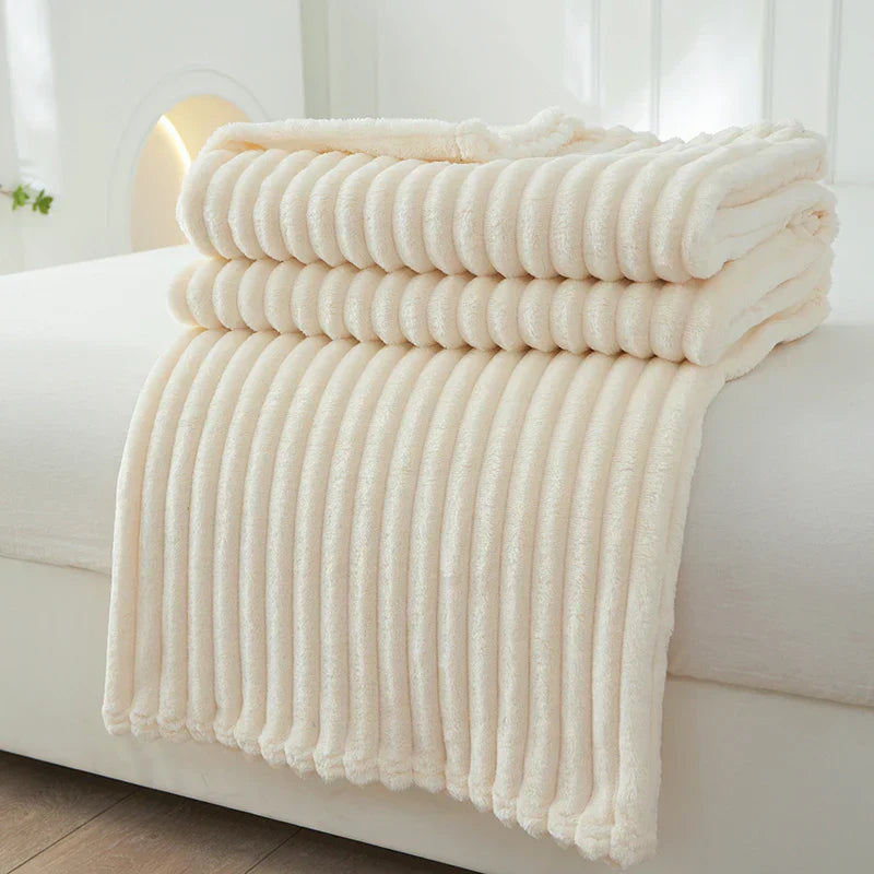 Cremefarbene, gestreifte Fleecedecke auf Bett, weich und kuschelig, ideal für Schlafzimmer.