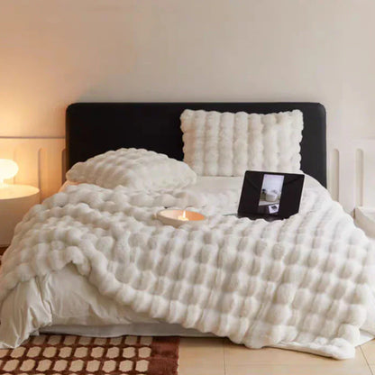 Weißes Plüschbettwäsche-Set mit Kissen und Decke auf modernem Bett, gemütliches Schlafzimmer-Dekor.