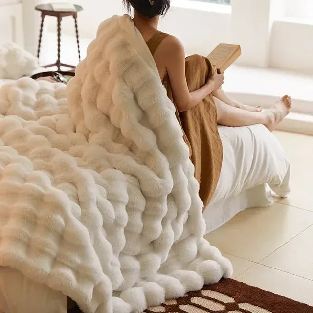 Frau mit Buch auf Sofa, weiße Kunstpelzdecke, gemütliches Wohnzimmer, modernes Interieur.