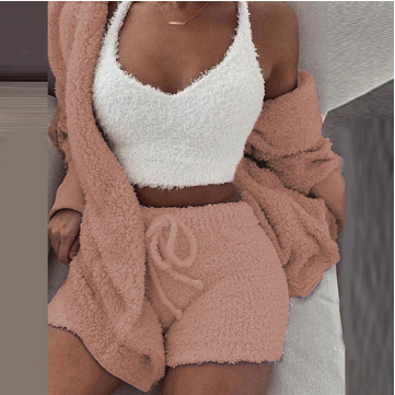 Frau in flauschigem rosa Lounge-Set mit weißem Top, gemütliche Damenmode, Herbstkleidung.