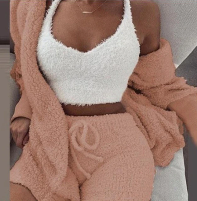Frau in flauschigem, cremefarbenem Top und rosa Shorts-Set, gemütliche Loungewear.