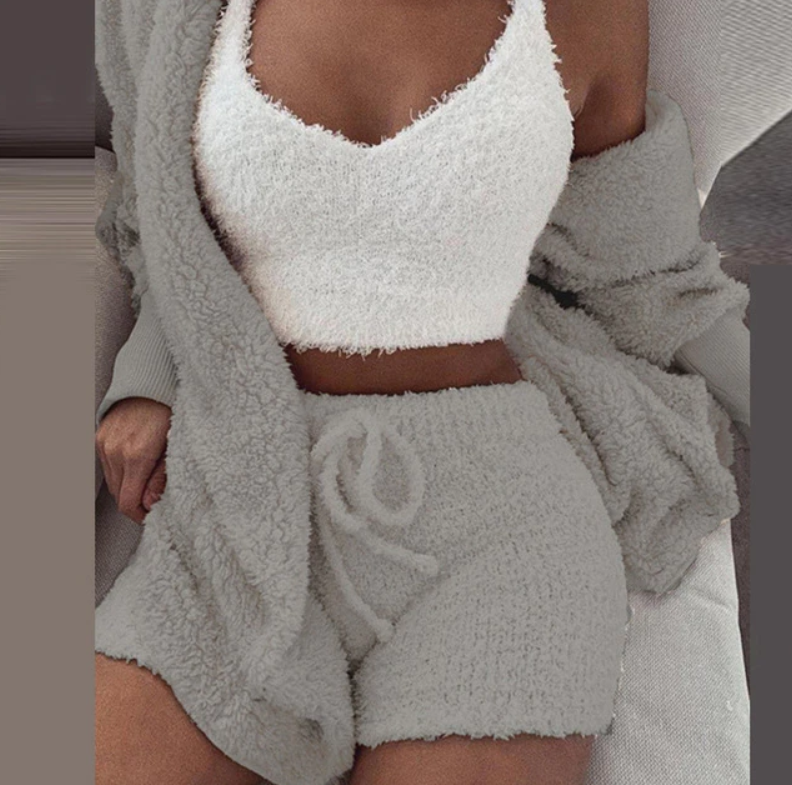 Frau in grauem Fleece-Set mit Shorts und weißem Top, gemütliche Loungewear, modisch, bequem.
