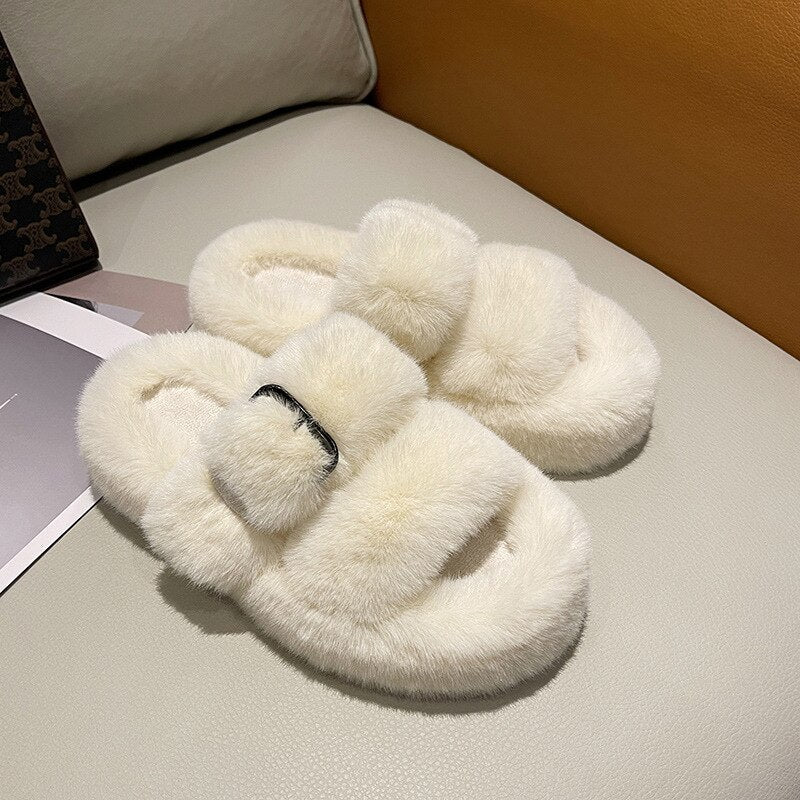 Weiße flauschige Hausschuhe aus Kunstfell auf Sofa, gemütlich, modisch, Damenmode.
