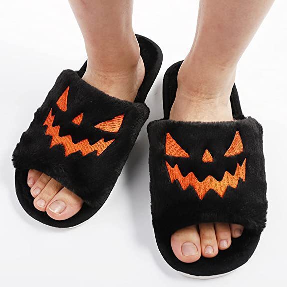 Schwarze Plüsch-Hausschuhe mit orangefarbenem Kürbisgesicht, Halloween-Design, Unisex.