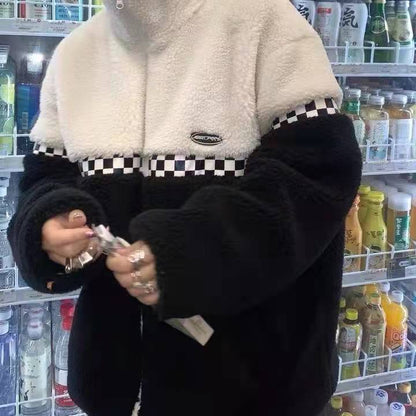 Person in schwarz-weißer Fleecejacke mit Karomuster vor Getränkekühlschrank.