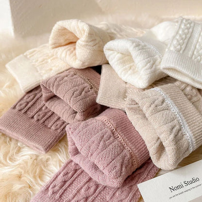 Mehrfarbige Strickstrümpfe aus Wolle, warm und gemütlich, ideal für den Winter, auf Fellunterlage.