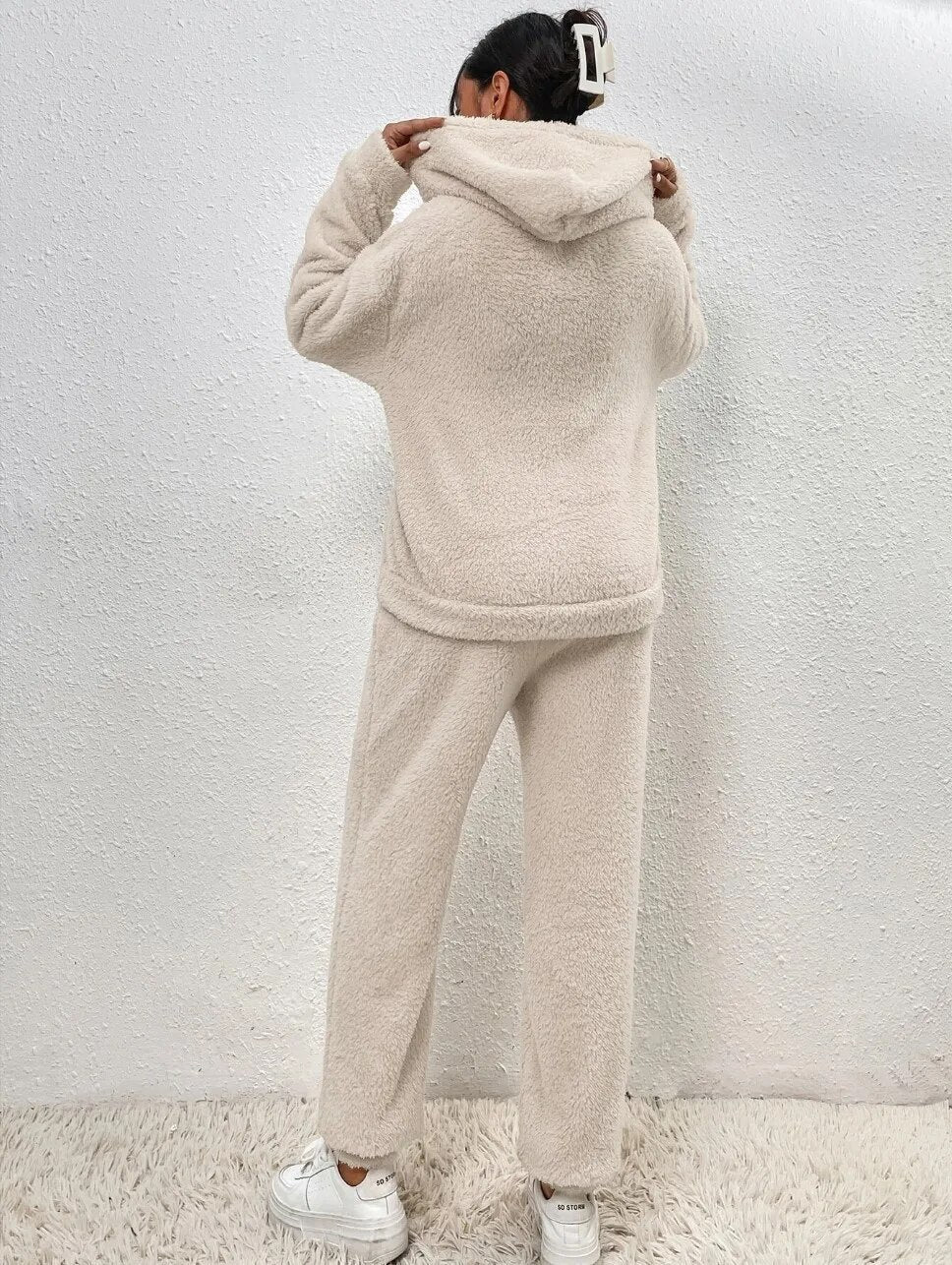 Frau in beigem Fleece-Hoodie und Jogginghose, gemütliche Wintermode, Rückansicht.