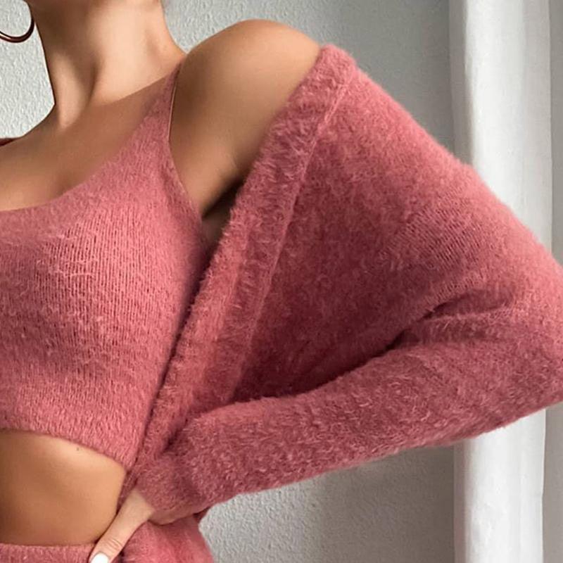 Frau in rosa Strickpullover-Set, schulterfrei, weiches Material, modisch, elegant.