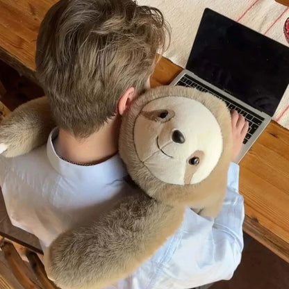 Ovanifrån sedd person vid laptop med ett sengångargosedjur som kramar om axlarna och nacken med långa armar. 9