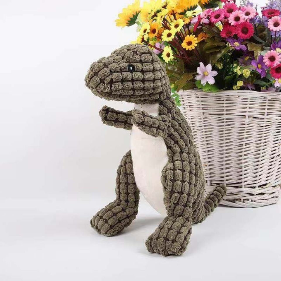 Plüsch-Dinosaurier in Grün vor weißem Korb mit bunten Blumen, Kuscheltier, Kinderzimmer-Deko.