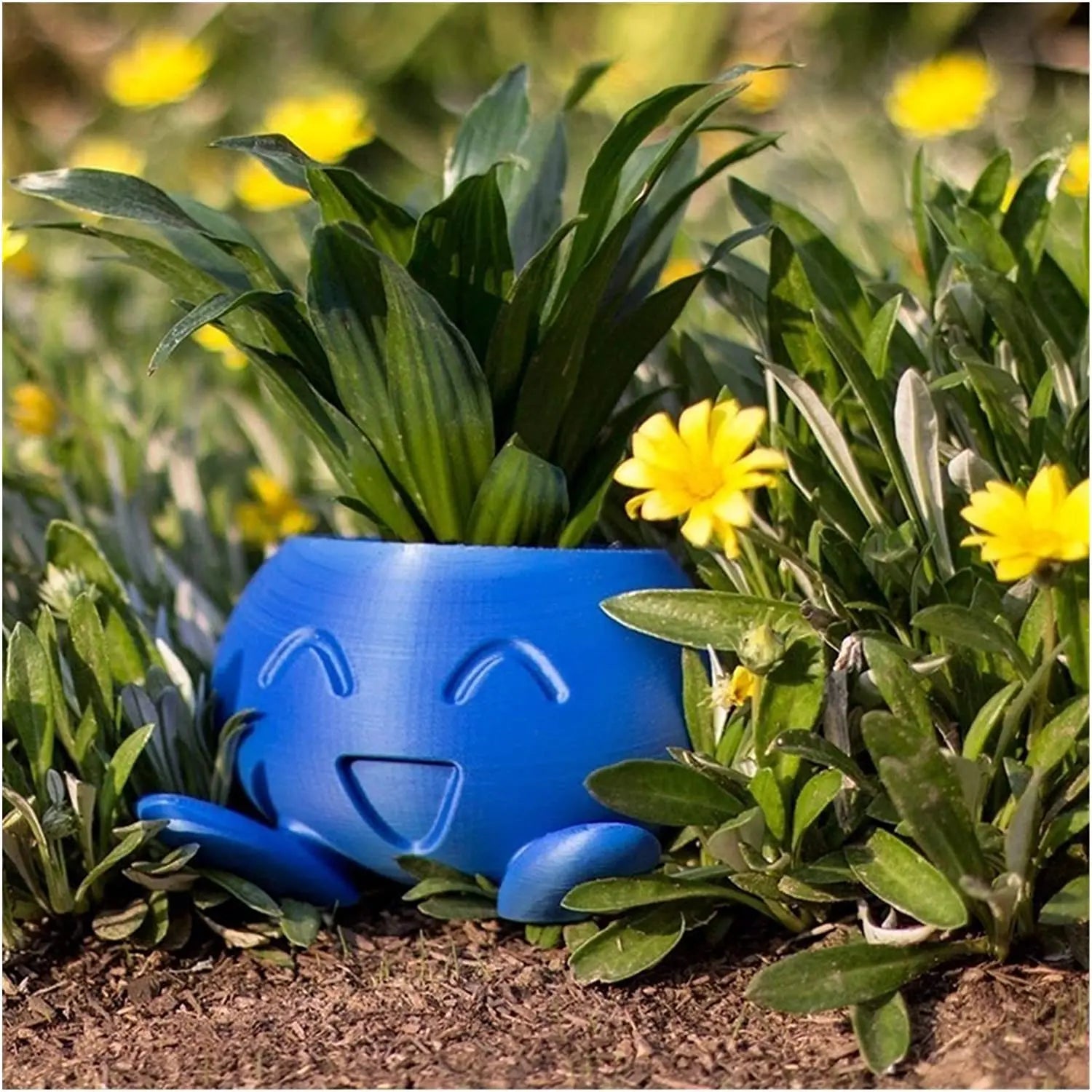 Blaue Pflanzentopf mit Gesicht, umgeben von gelben Blumen im Garten, fröhliches Design.