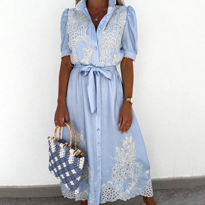 Frau in hellblauer Maxikleid mit Spitze, hält geflochtene Tasche, elegantes Sommeroutfit.