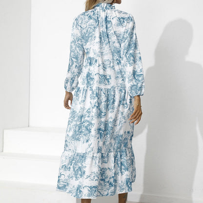 Frau in langem, blau-weißem Kleid mit floralem Muster, Rückansicht, modisch, elegant.