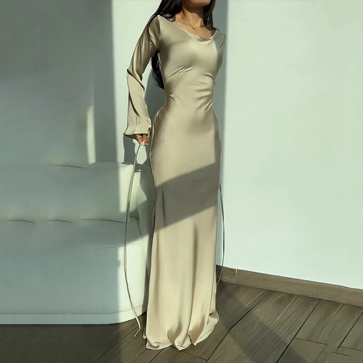Frau in langem, beigem Satinkleid, elegantes Abendkleid, modernes Design, Innenraum.