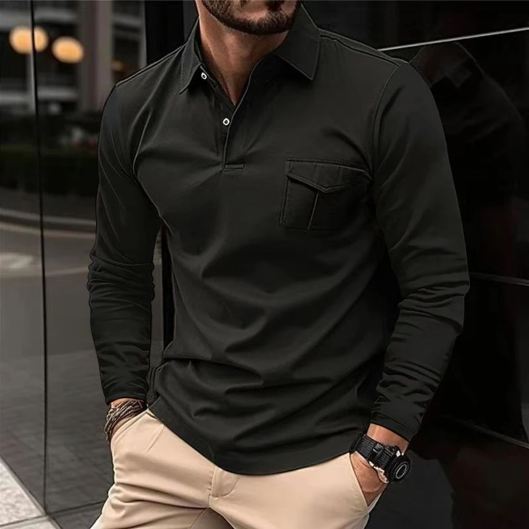 Mann in schwarzem Langarm-Poloshirt, beige Hose, Armbanduhr, urbaner Hintergrund.