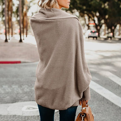 Frau in beiger Strickjacke auf Straße, modische Damenbekleidung, Herbstmode, Rückansicht.