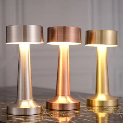 Drei LED-Tischlampen aus Metall in Silber, Kupfer und Gold auf Marmortisch, kabellos, Touchsensor.