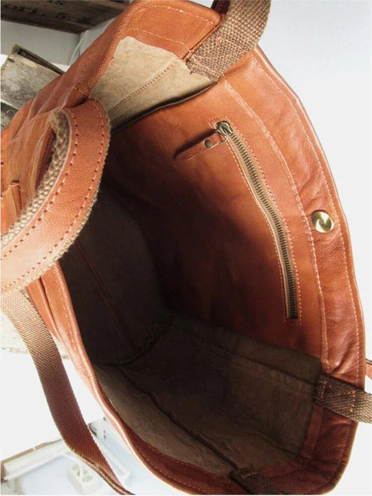 Braune Ledertasche mit Reißverschlussfach, robustem Stofffutter und Tragegriffen.