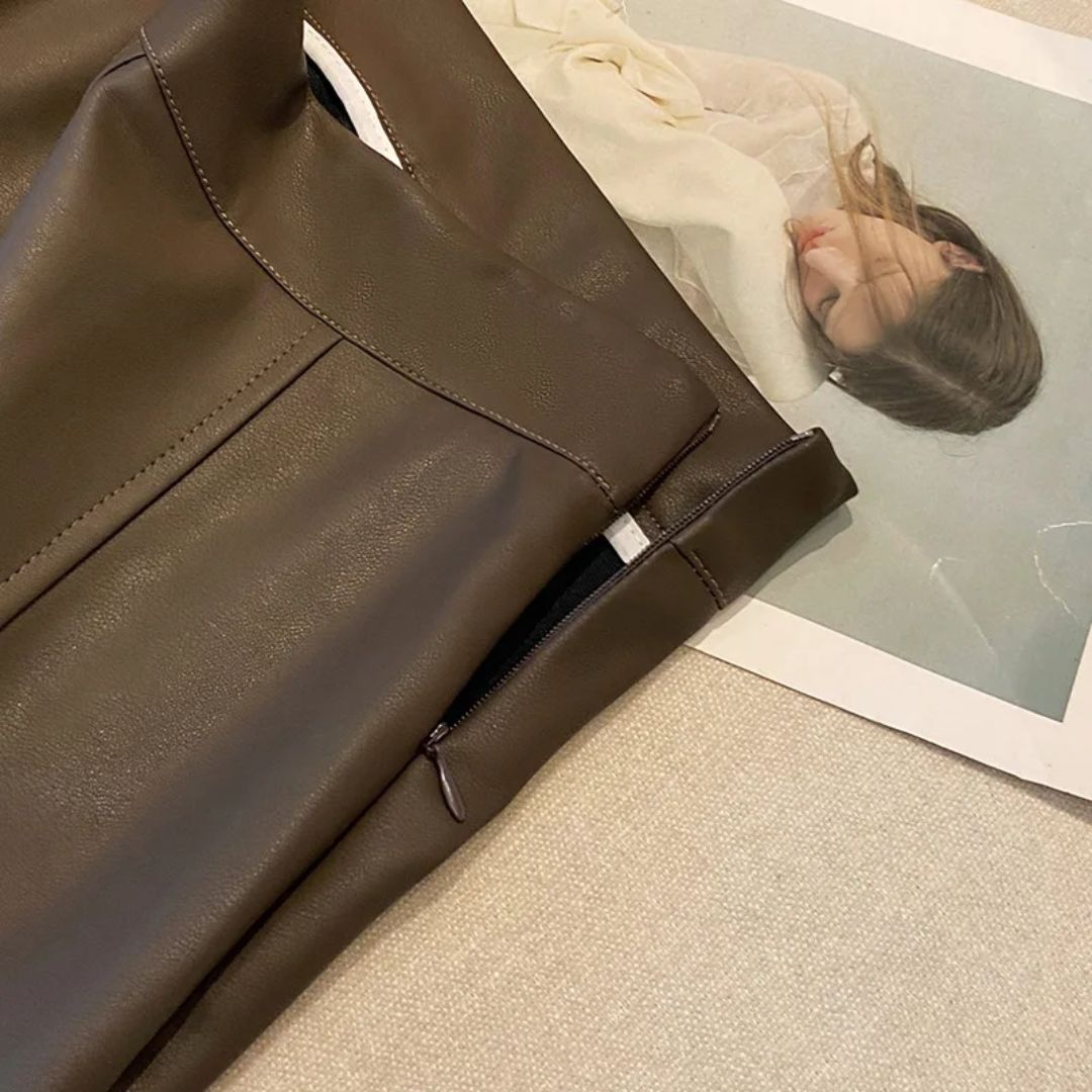Braune Lederhose mit Reißverschluss, Damenmode, elegantes Design, auf beigem Hintergrund.