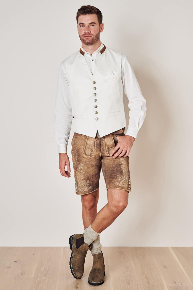 Mann in weißer Weste und Lederhose, Trachtenmode, traditionell, bayerisch, Oktoberfest-Outfit.